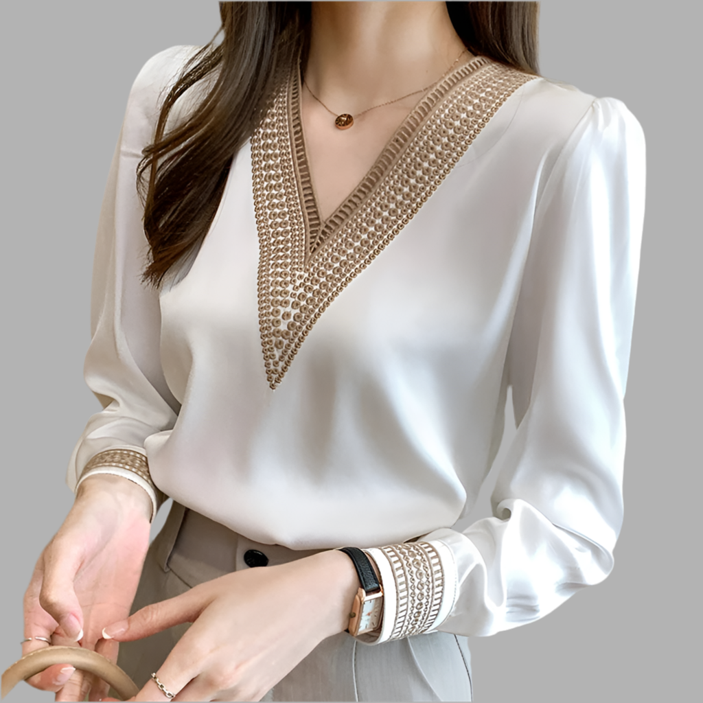 White blouse with gold embroidery on a gray background