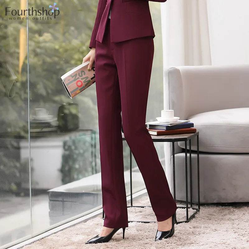 Woman in a burgundy suit standing in a modern living room.