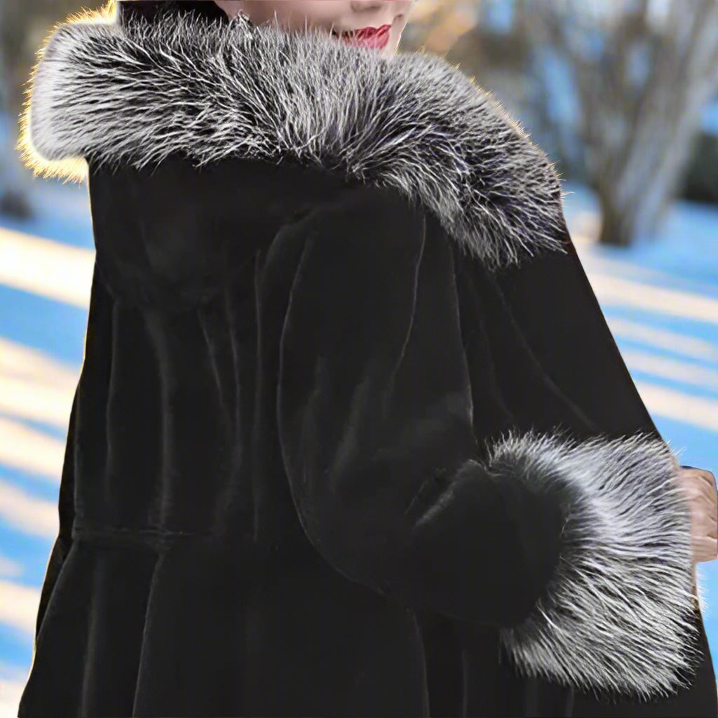 Black coat with fur trim worn by a model on a brown background