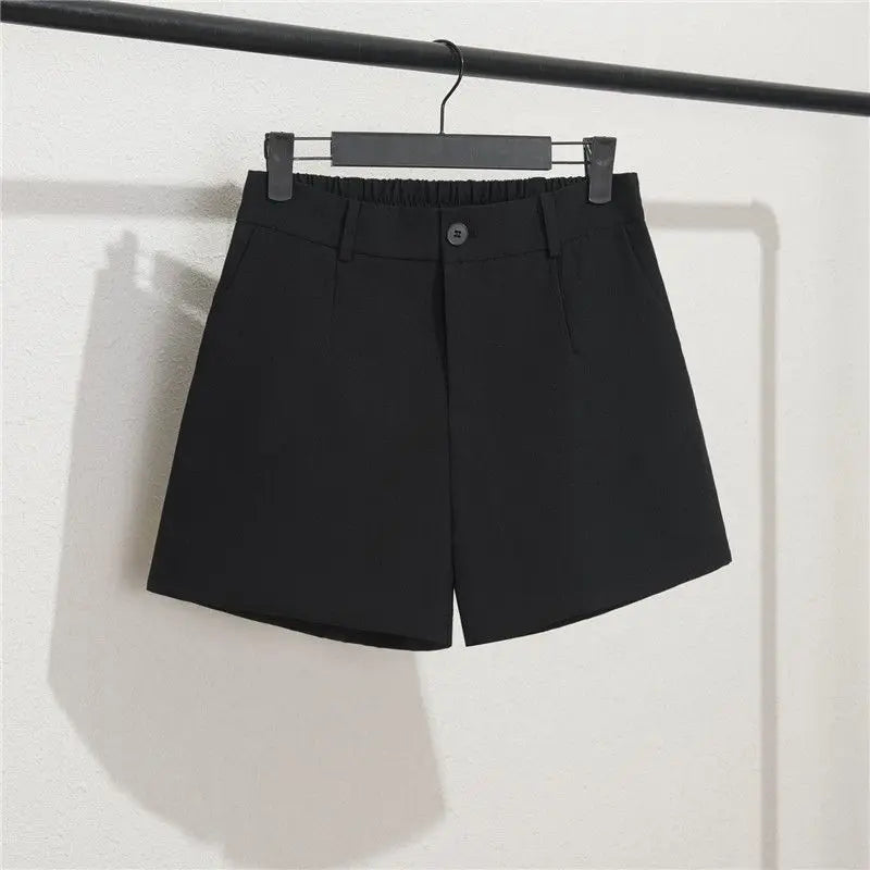 Black shorts on a hanger against a white background
