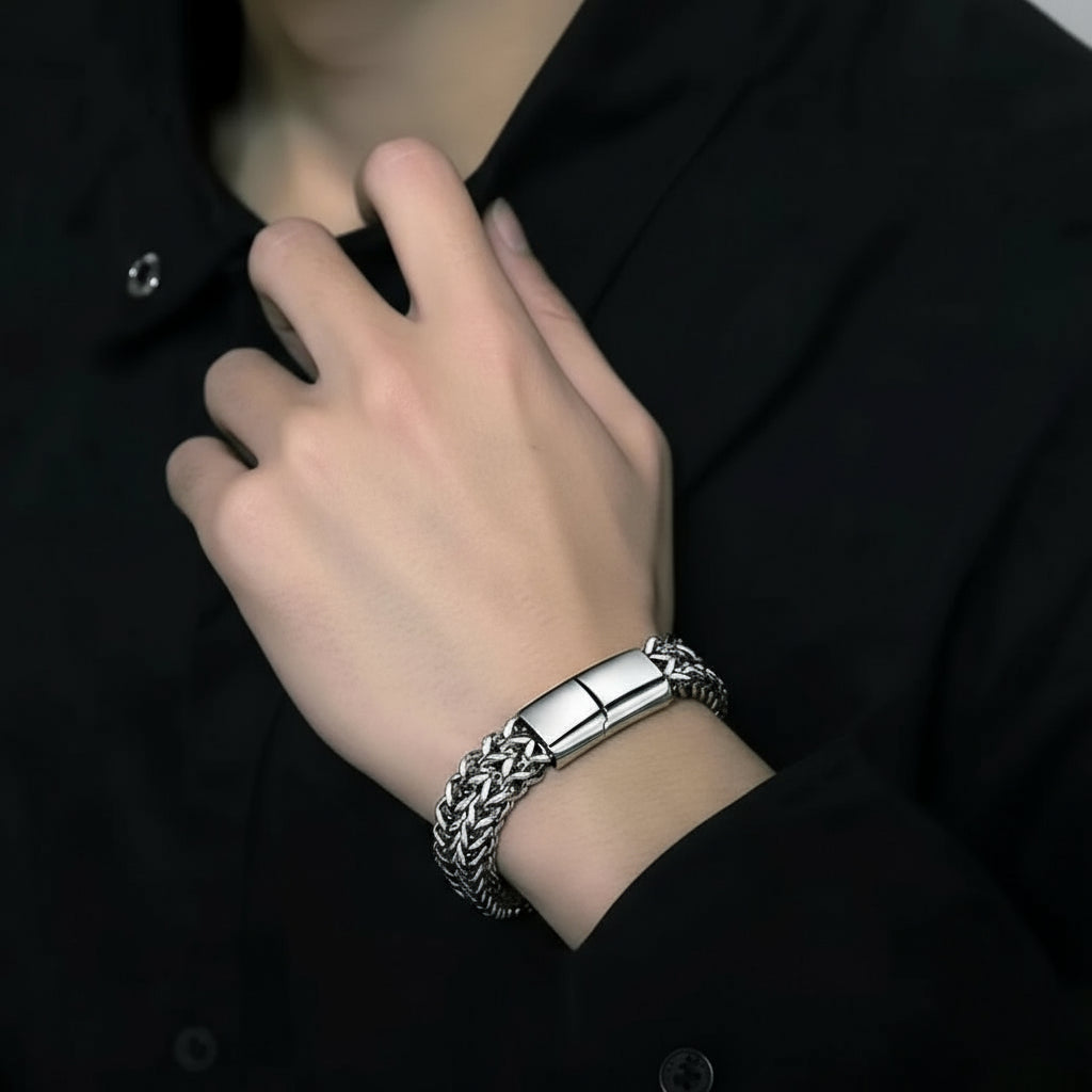 Silver bracelet on a person's wrist with a dark background