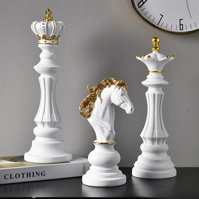 Decorative chess pieces with crowns on a surface, including a horse figure.