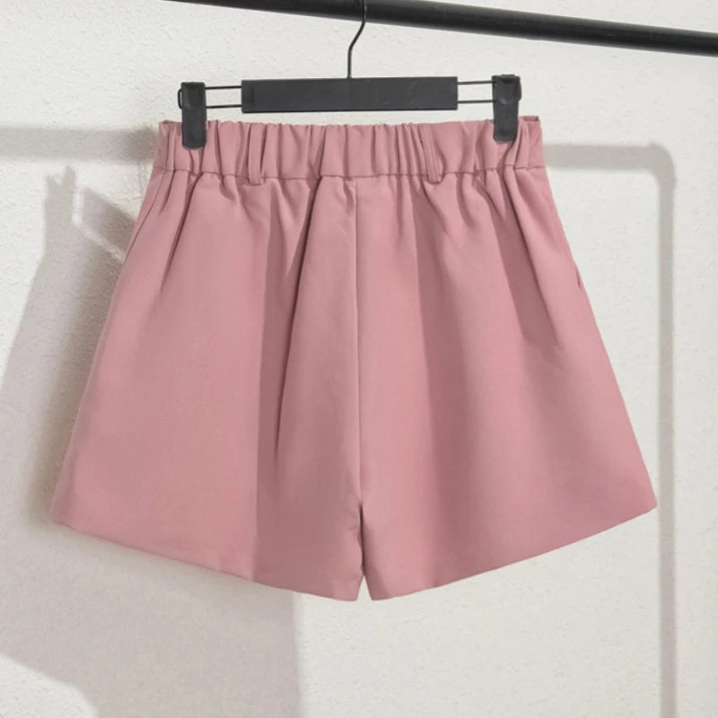 Pink shorts hanging on a black hanger against a white background