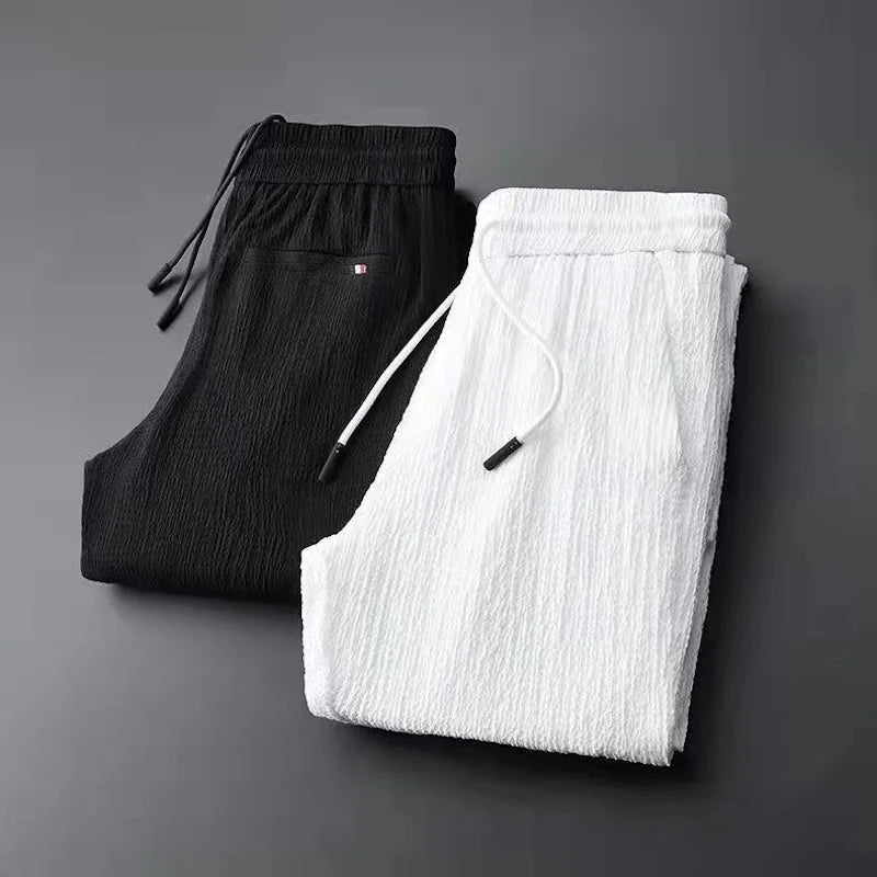 Black and white pants stacked on a dark gray background