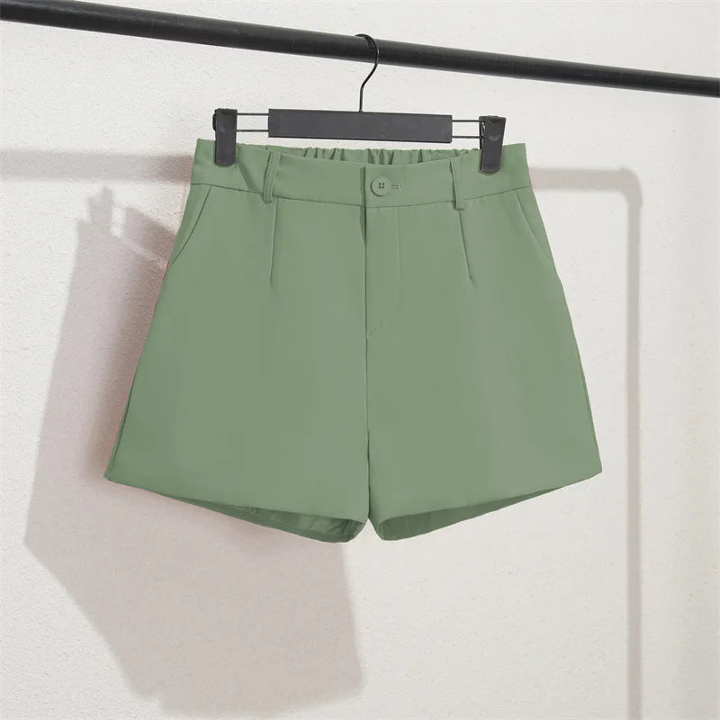 Green shorts on a hanger against a white background