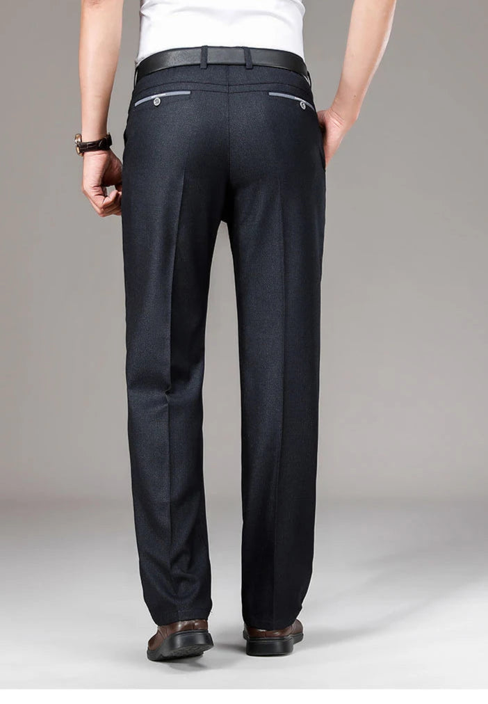 Person wearing black dress pants on a plain background