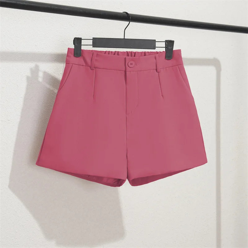 Pink shorts on a hanger against a white background