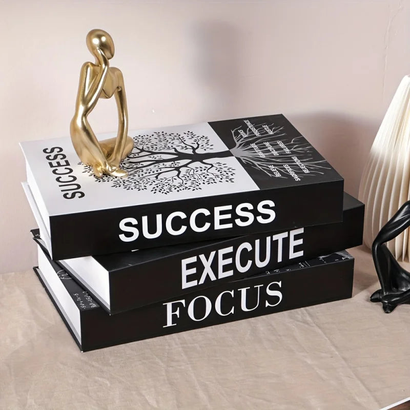 Stack of books with motivational phrases on a surface, accompanied by decorative statues.