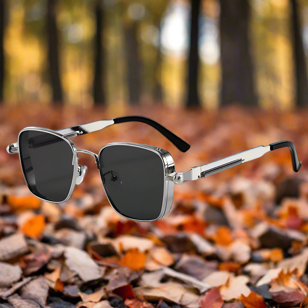 Sunglasses with silver frame and black lenses on a white background