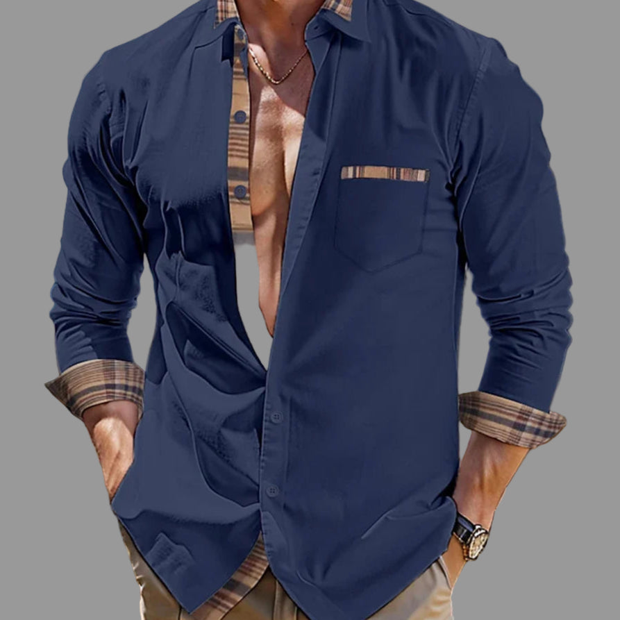 Man wearing a navy blue shirt with plaid accents outdoors