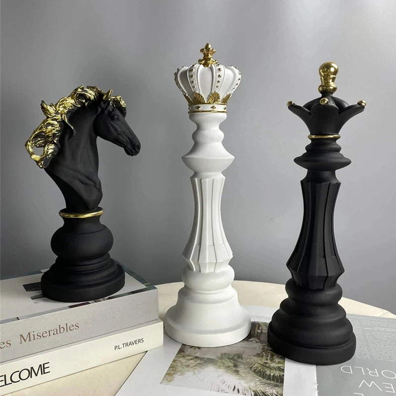 Decorative chess pieces with crowns on a book against a gray background
