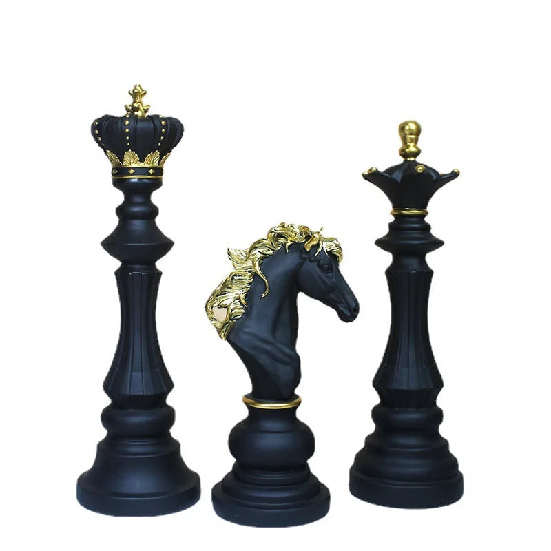 Black chess pieces with gold detailing on a white background