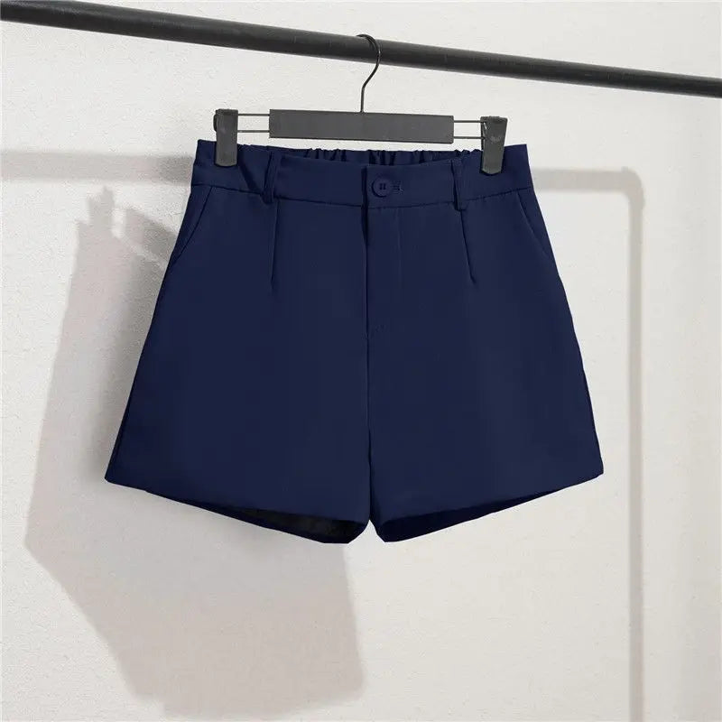 Navy blue shorts hanging on a rack against a white background