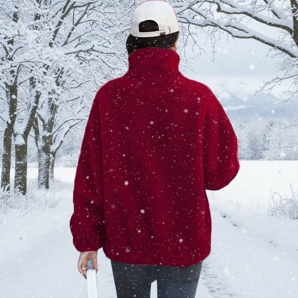 Person wearing a red jacket and white cap walking past a store with 'Mobilia' branding.