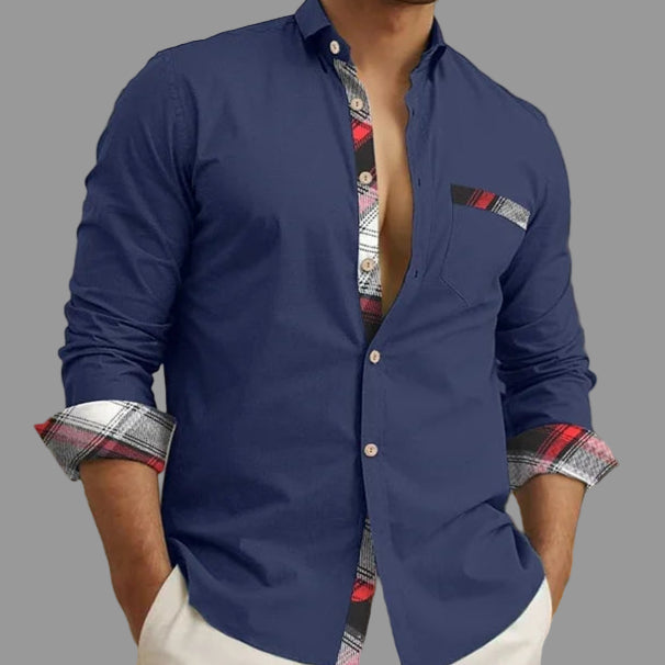 Man wearing a blue shirt with patterned cuffs and collar in an indoor setting