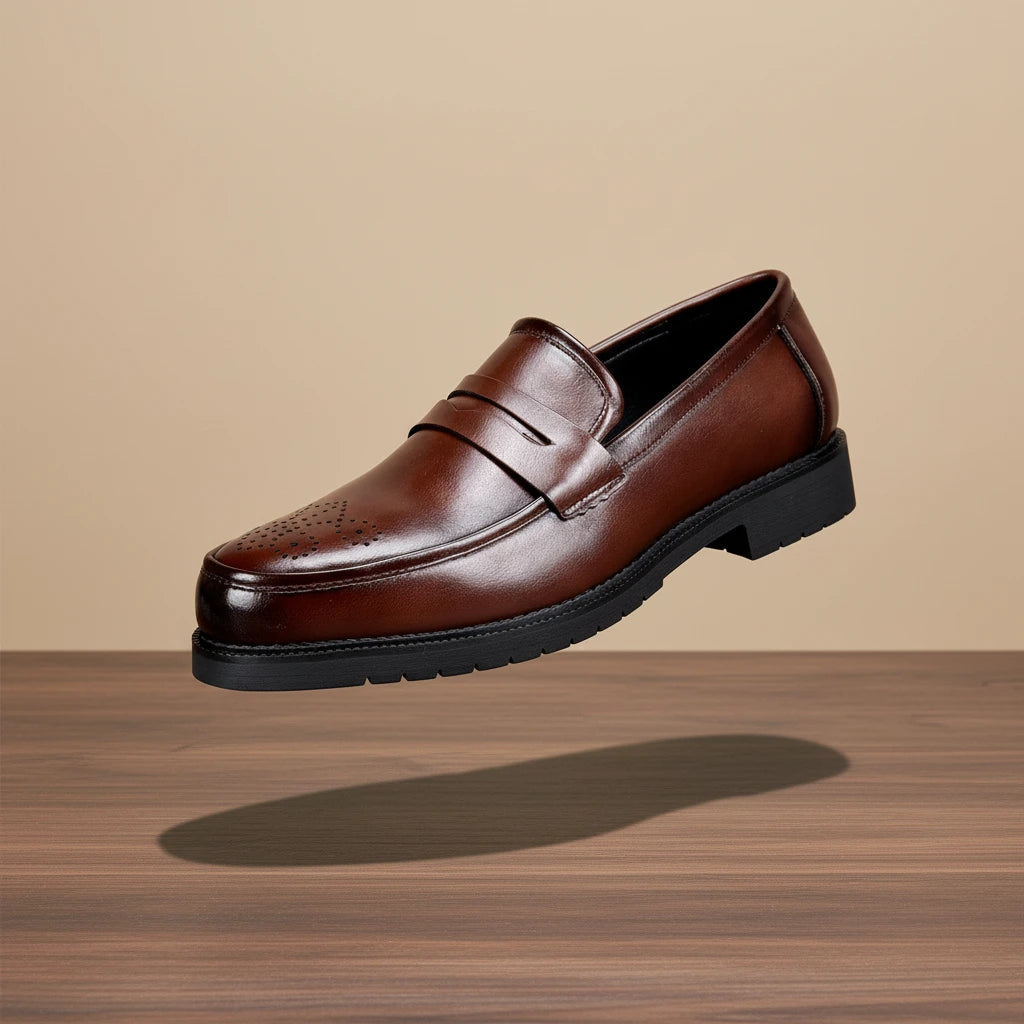 Brown leather loafer shoe on a wooden surface with a beige background