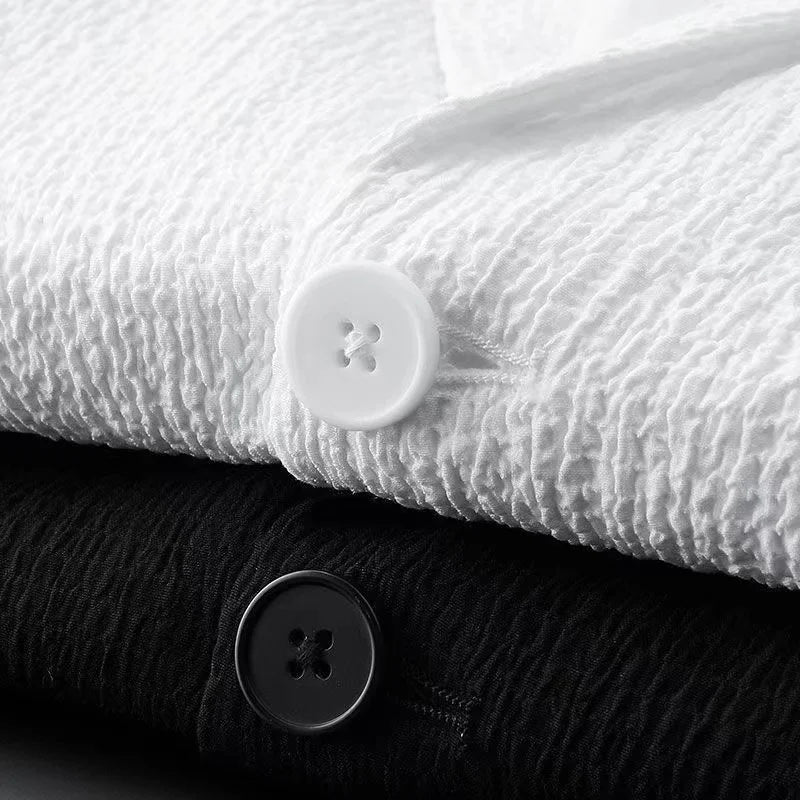 Close-up of textured white fabric with a button on top and black fabric below.