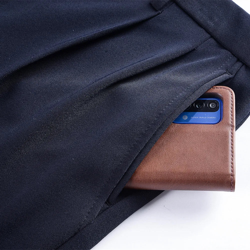 Smartphone in a brown leather case peeking out from a black fabric pocket.