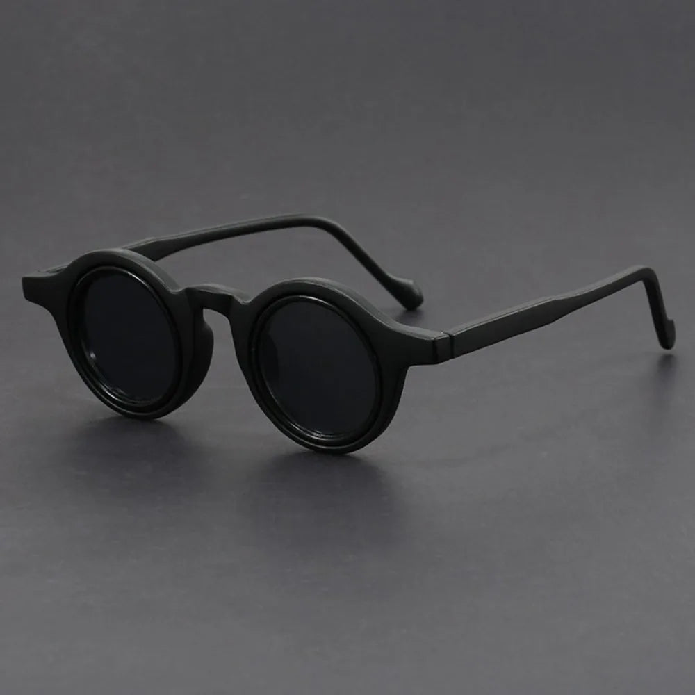 Black round sunglasses on a gray background