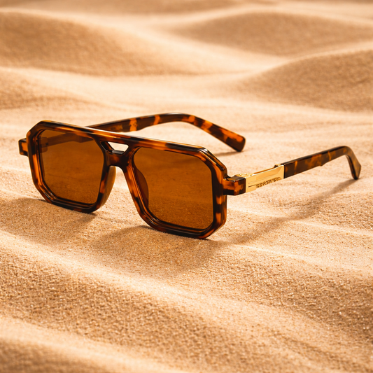 Sunglasses with tortoiseshell frame and brown lenses on sand