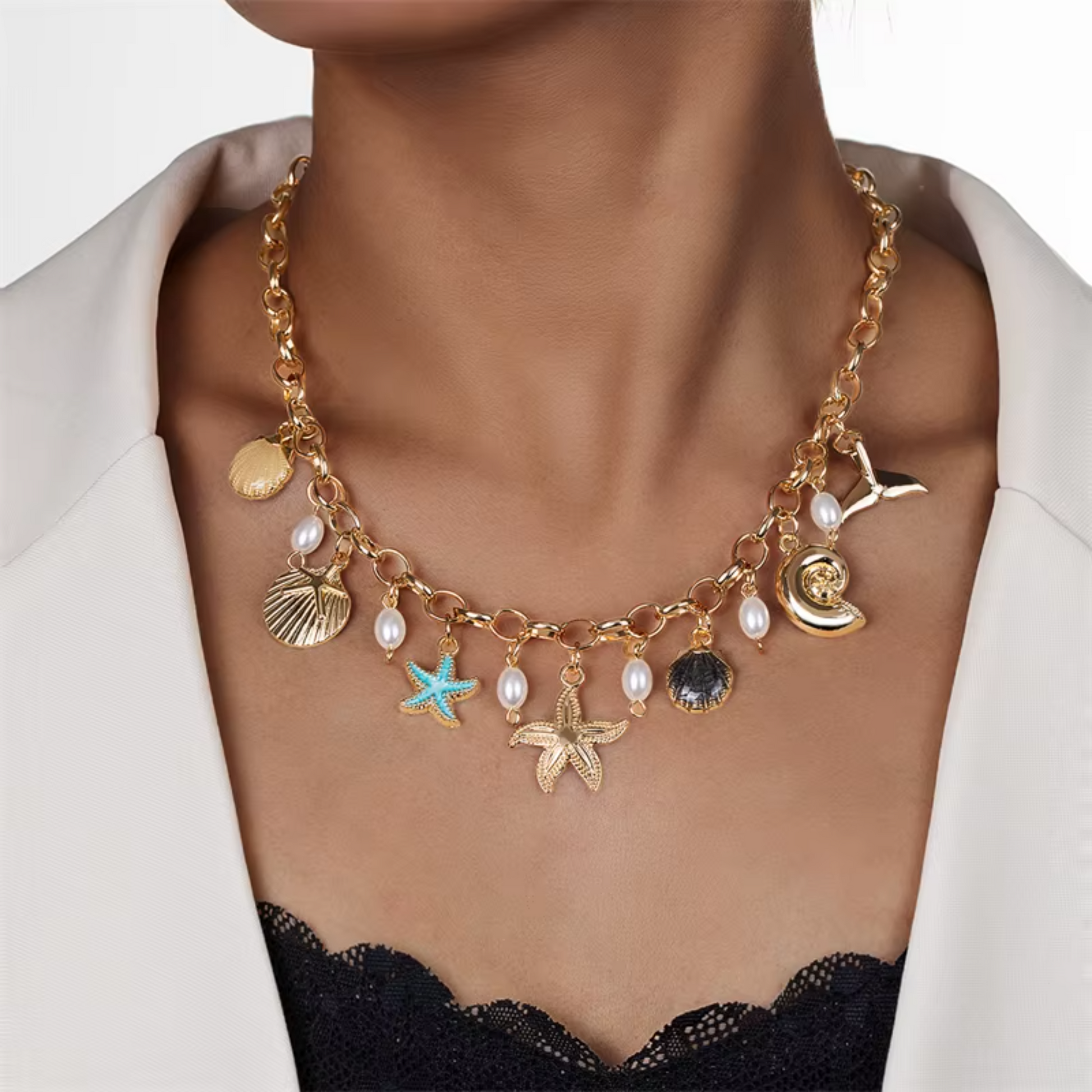 Necklace with various charms including stars and shells on a person wearing a white jacket.