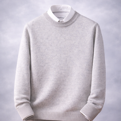 Gray sweater on a wooden table with a gray background