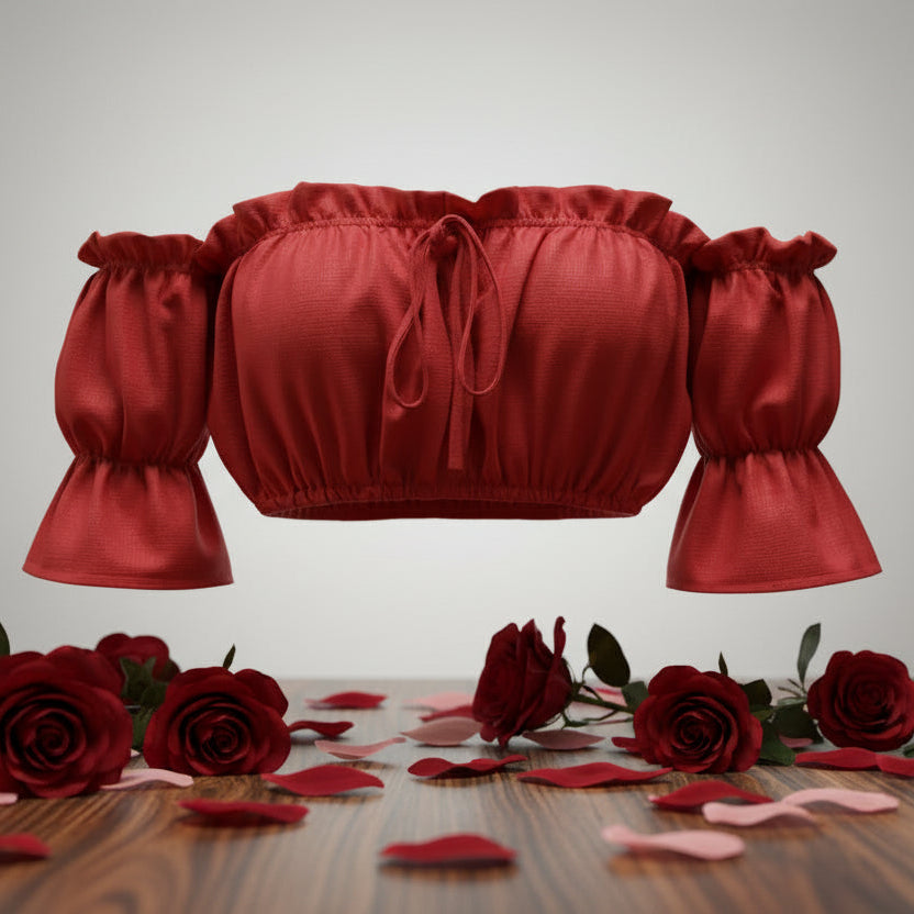Red crop top with puff sleeves on a wooden surface with red roses.