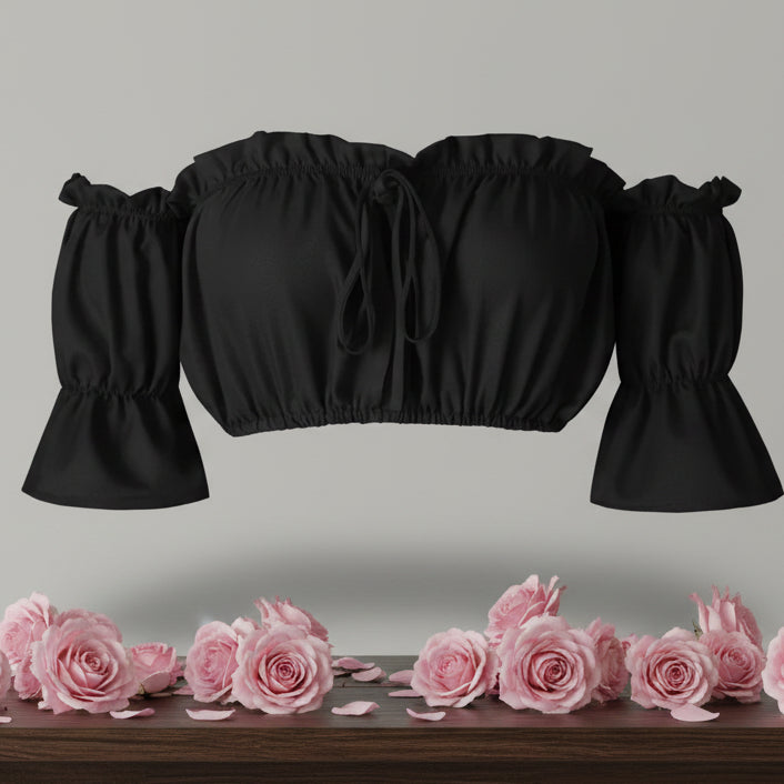 Black crop top with puff sleeves on a gray background with pink roses at the bottom.