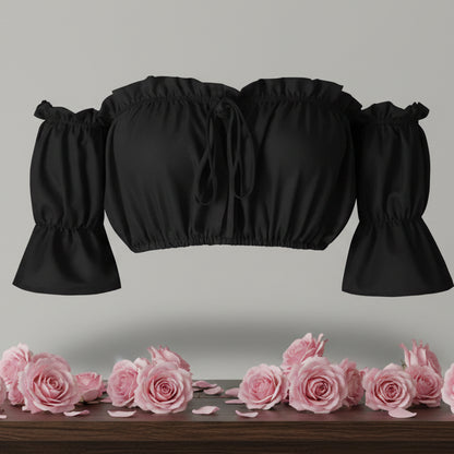 Black crop top with puff sleeves on a gray background with pink roses at the bottom.