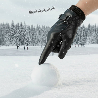 Black glove making a snowball in a snowy landscape with a Santa Claus sleigh in the sky.
