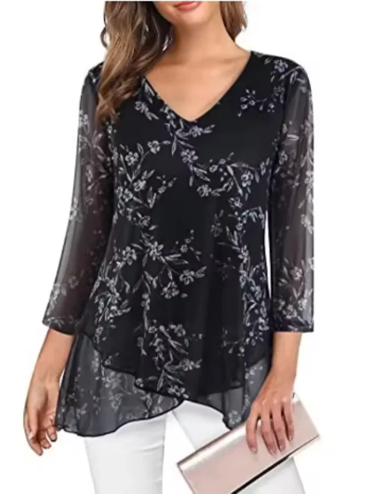 Black floral-patterned blouse worn by a person on a white background