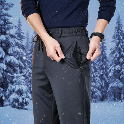 Person wearing dark grey pants with a snowy forest background 