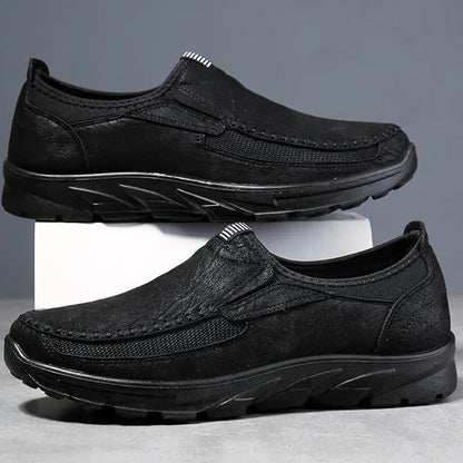 Two pairs of black and gray loafers on a gray background