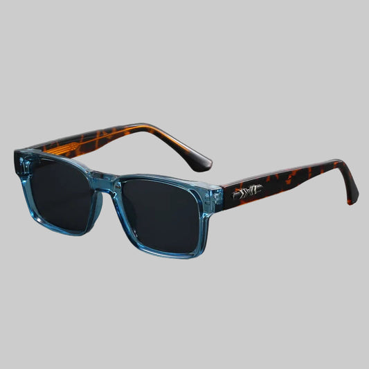 Sunglasses with blue frame and tortoiseshell arms on a gray background