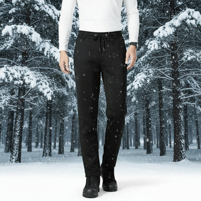 Person wearing black pants standing in a snowy forest