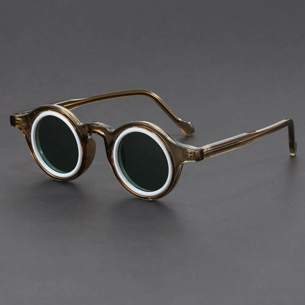 Round eyeglasses with gold frame and dark lenses on a gray background