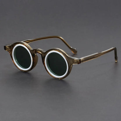 Round eyeglasses with gold frame and dark lenses on a gray background