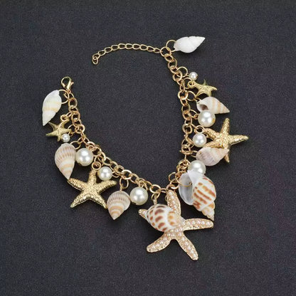 Bracelet with starfish, shell, and pearl charms on a dark background