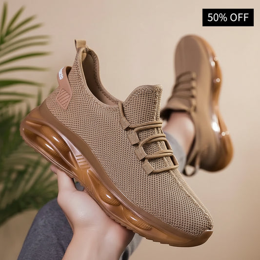 Brown athletic shoe held by a hand with blurred background