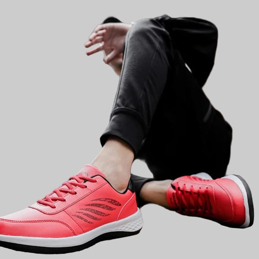 Person wearing red sneakers sitting on a street with a blurred background