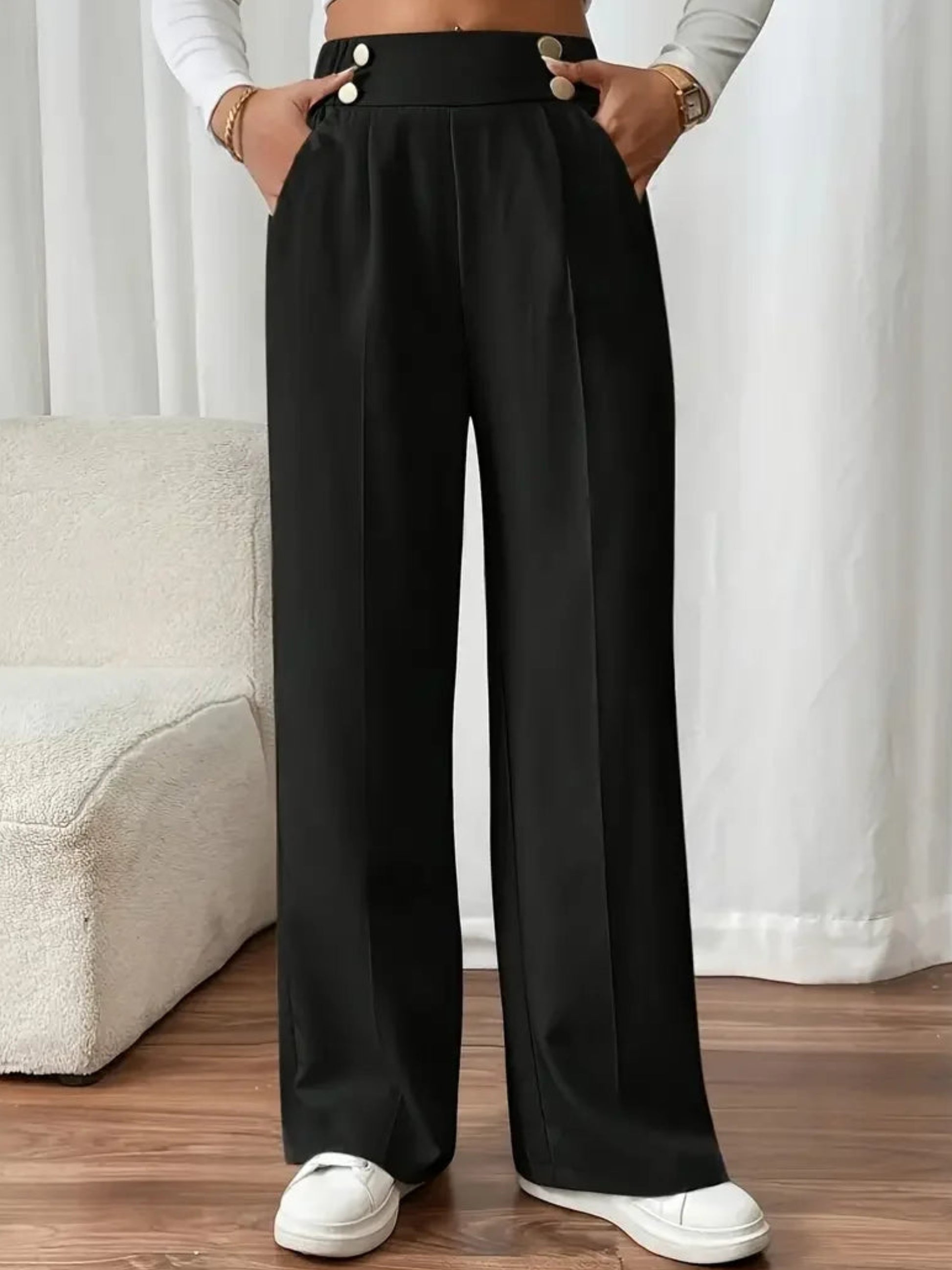 Person wearing black wide-leg pants with a white background
