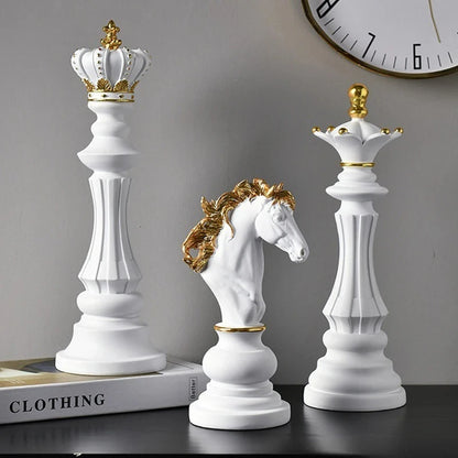 Decorative chess pieces with crowns on a surface, including a horse figure.