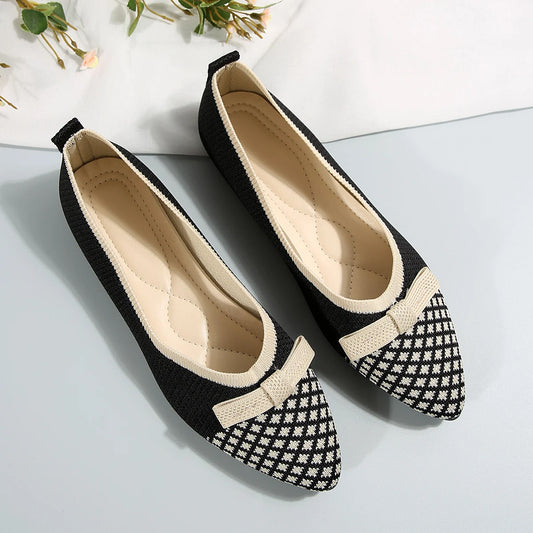 Black and white checkered shoes with a bow on a light gray background