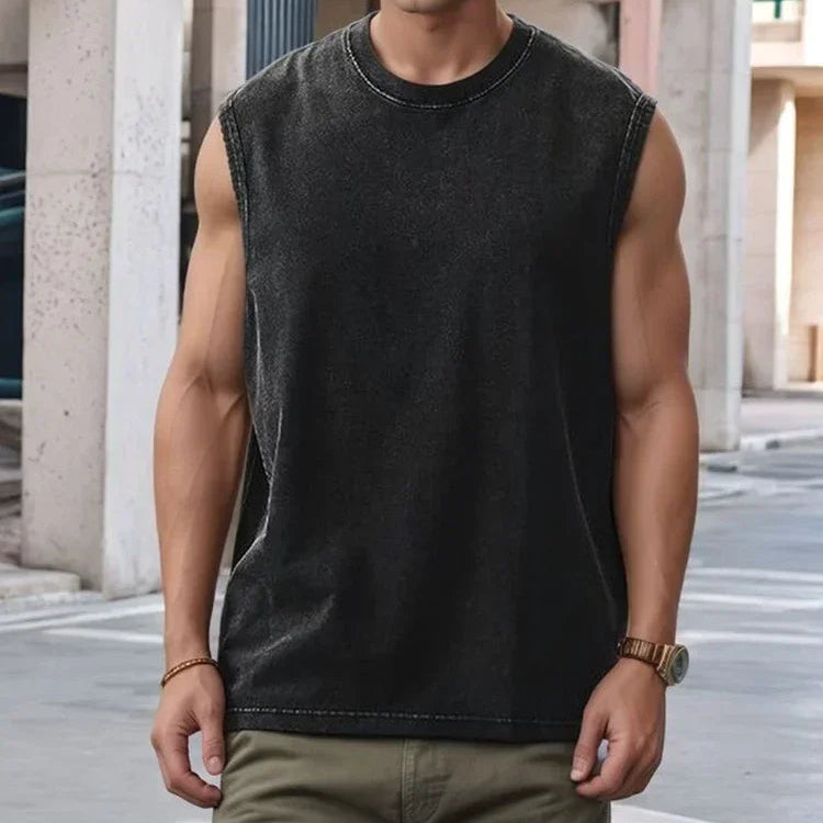 Man wearing a black sleeveless shirt standing in an urban setting