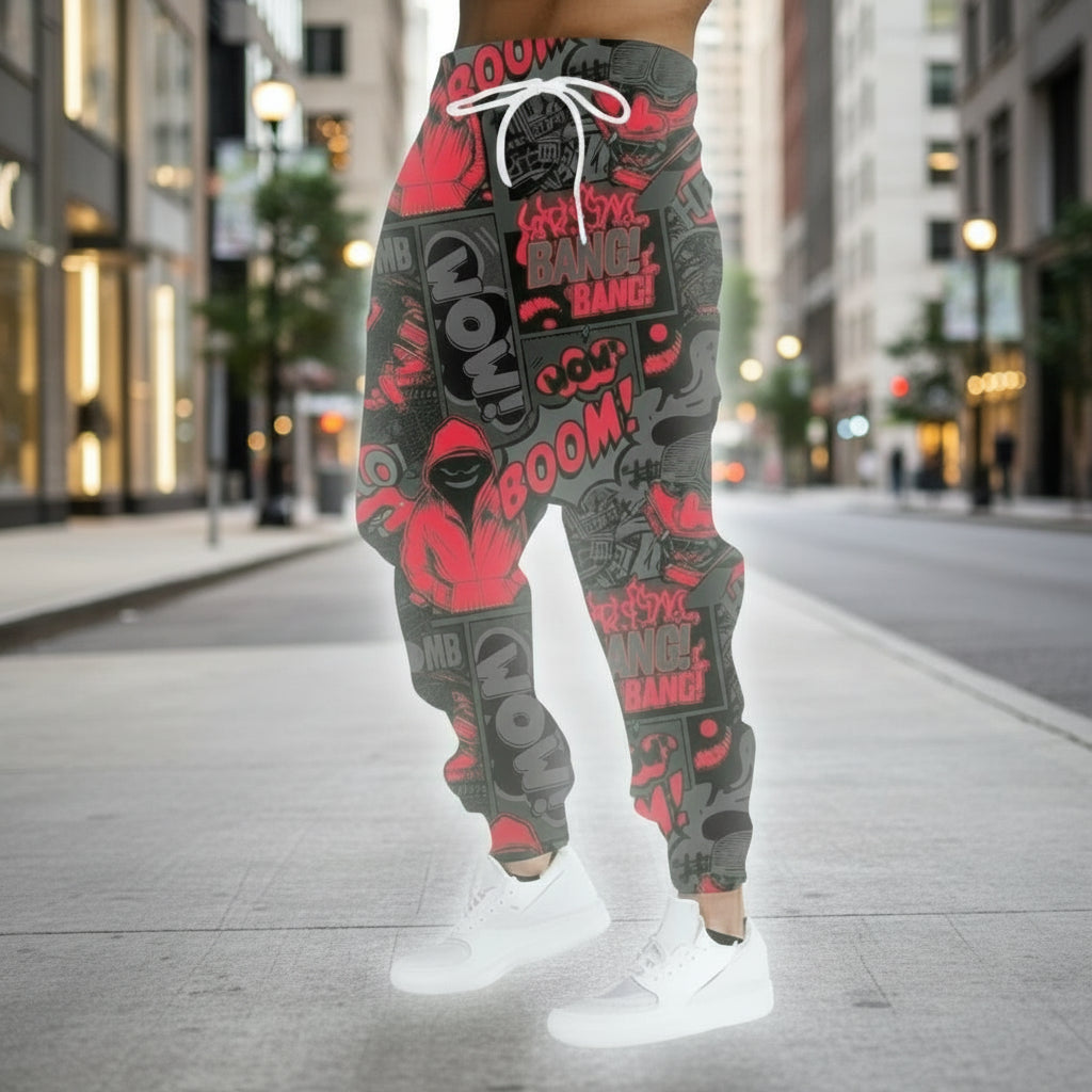 Person wearing black and red graffiti-style pants with white text against a graffiti-covered wall.