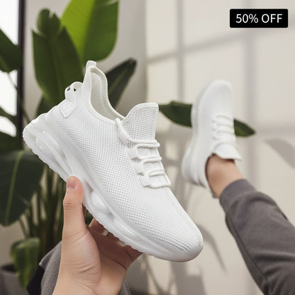 White sneakers worn on a dark pavement surface