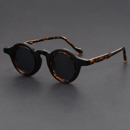 Round sunglasses with tortoiseshell frame on a gray background