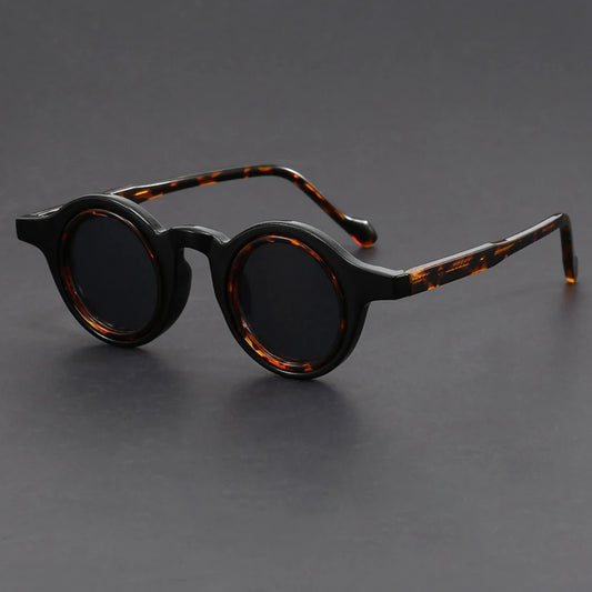 Round sunglasses with tortoiseshell frame on a gray background