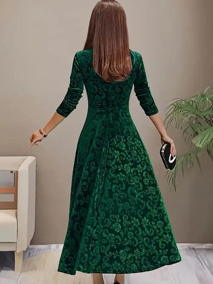 Woman wearing a green patterned dress in an indoor setting