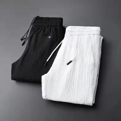 Black and white pants stacked on a dark gray background